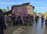 Bahu Membahu, Brimob Pindahkan Rumah Terseret Banjir yang Melintang di Jalan Nasional Tamiang–Langsa